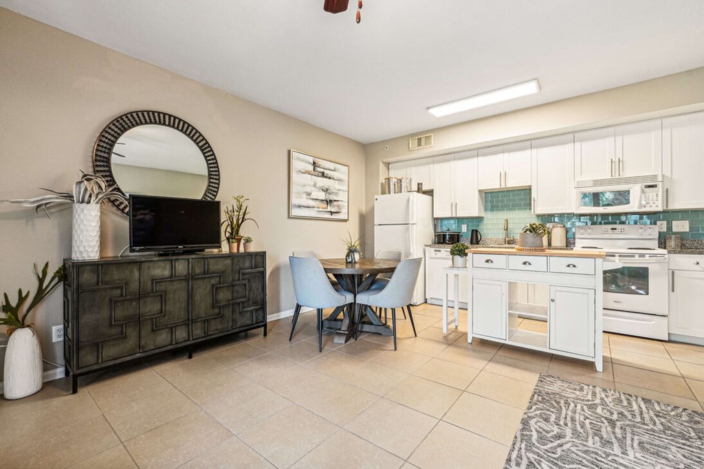 A kitchen with a dining table and chairs.