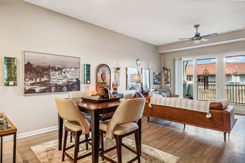 A dining room with a table and chairs and a picture on the wall.