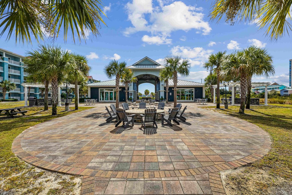 A circular brick patio with a table and chairs in the middle.