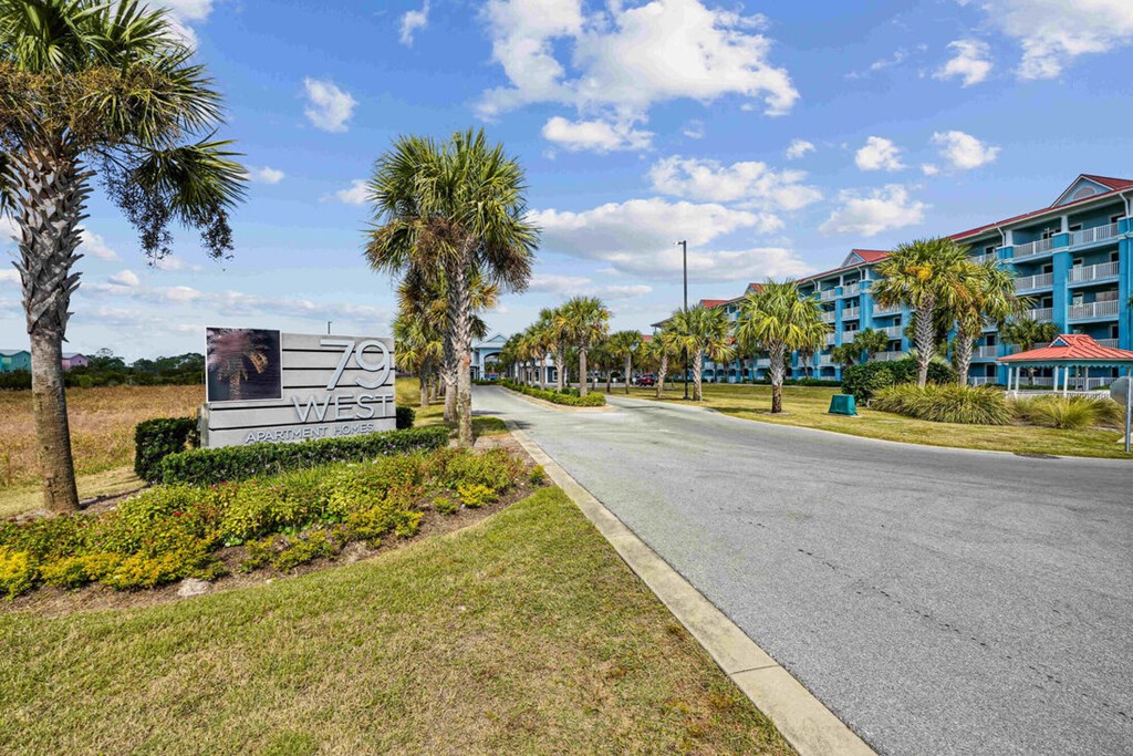 A road with a sign that says "Zen West" in front of a building.