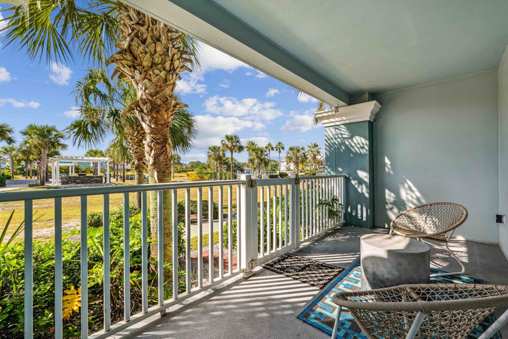 A balcony with a chair and a table with a wicker chair and a table.