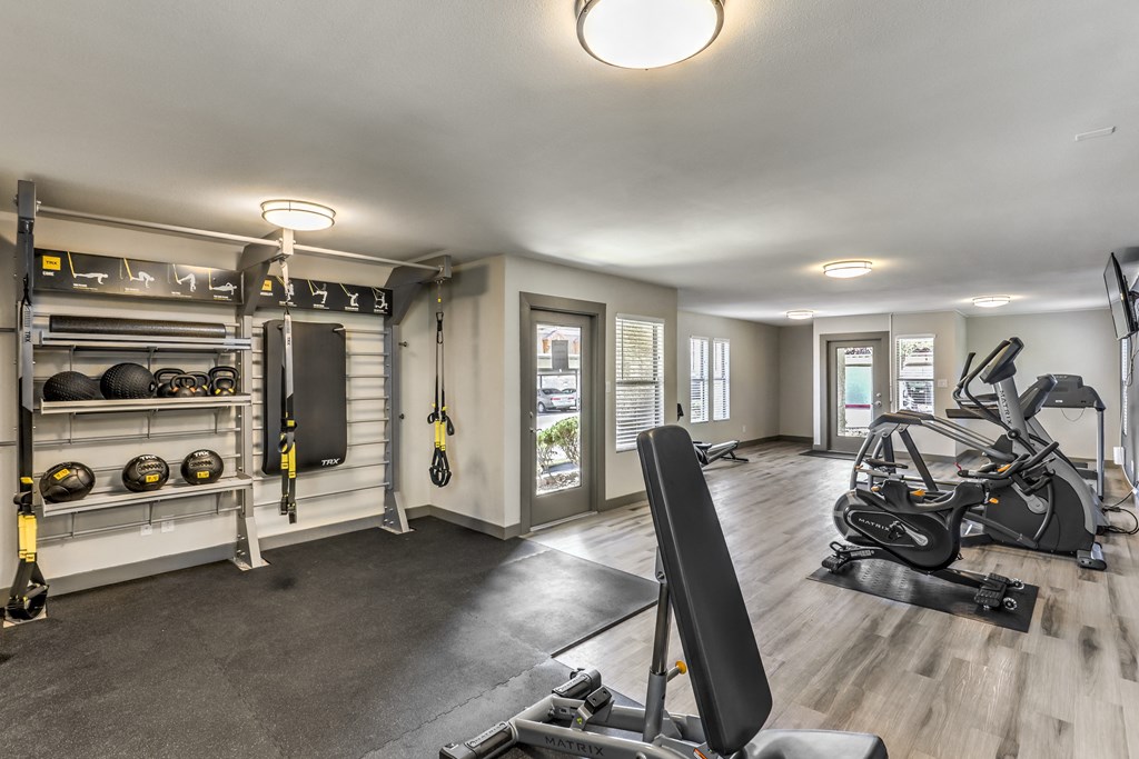 a home gym with weights and equipment and a door to a balcony