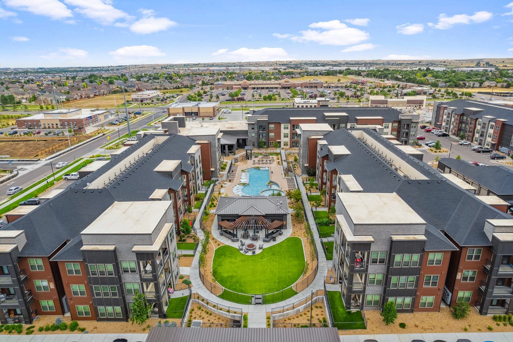 an aerial view of an apartment complex with a pool in the middle