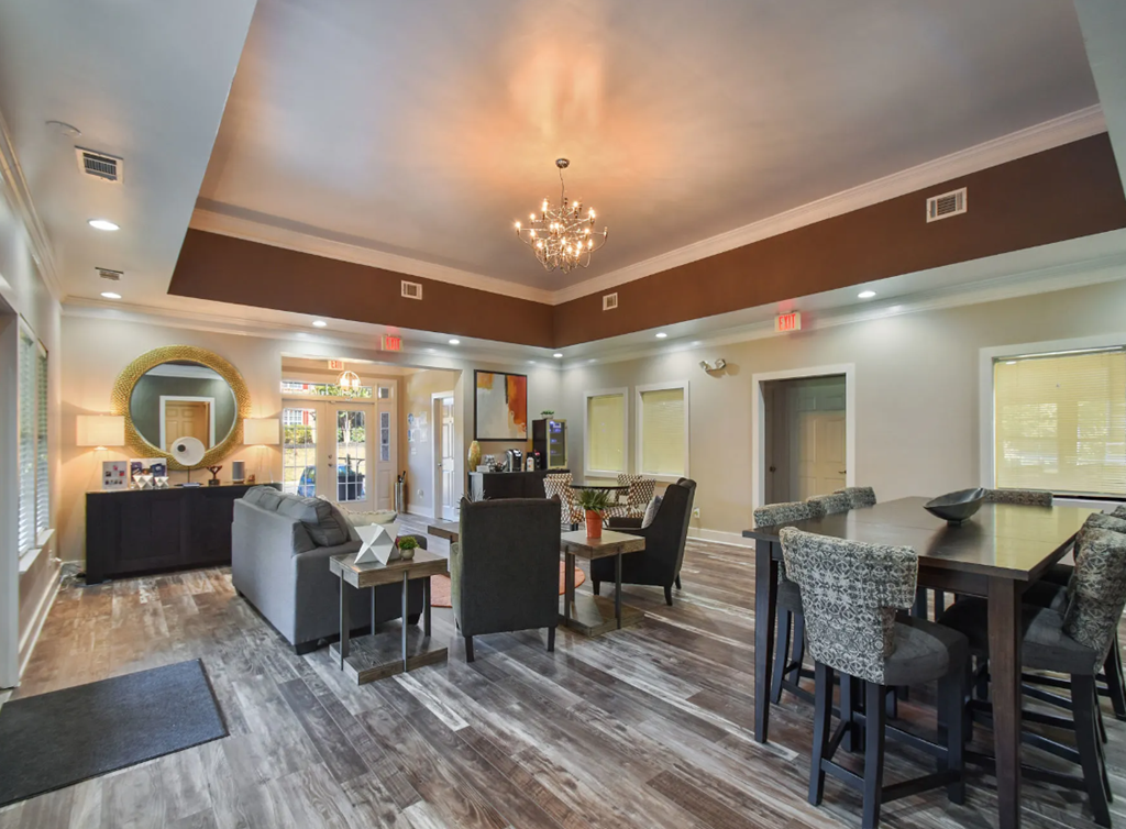 a resident clubhouse with couches tables and chairs and a large chandelier