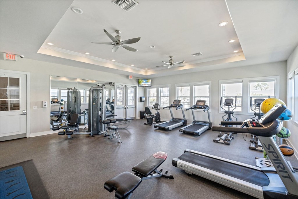 A spacious gym with treadmills, exercise bikes, and other equipment.
