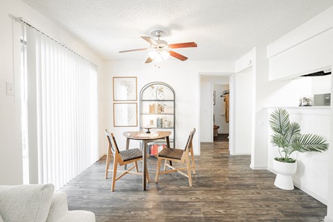 a dining room with a table and chairs and a ceiling fan