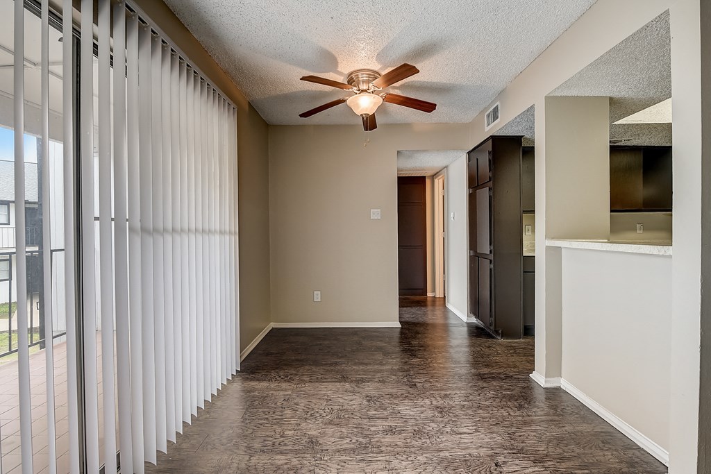 a living room with a ceiling fan and a large window