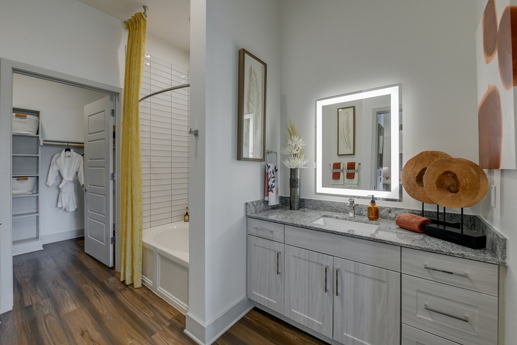 A bathroom with a white tub and a yellow curtain.