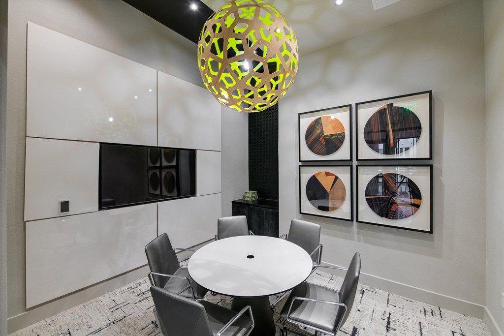 a conference room with a round table and chairs and pictures on the wall