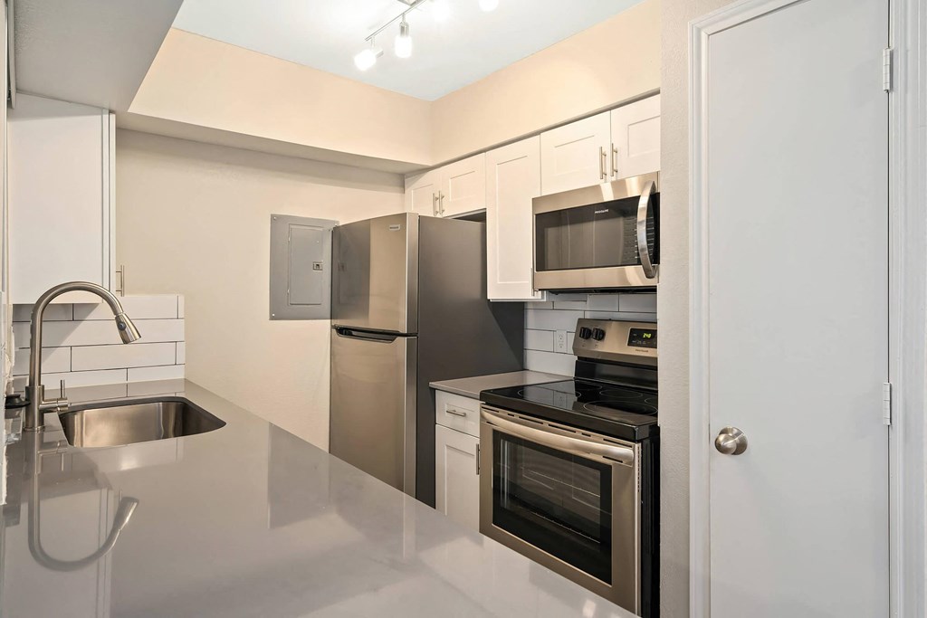 a kitchen with white cabinets and stainless steel appliances