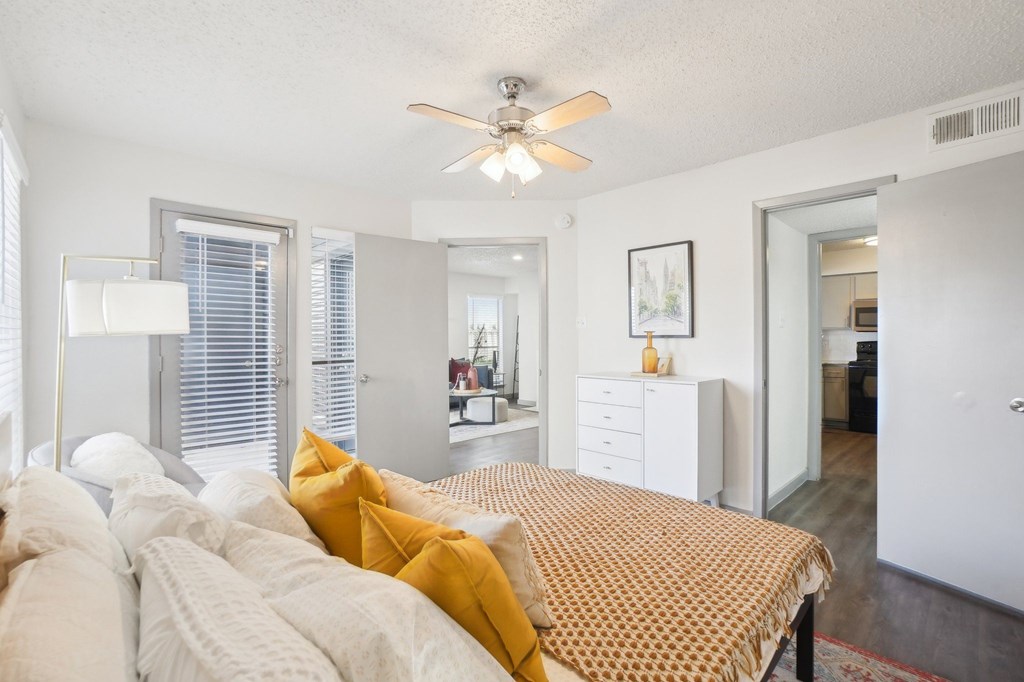 A bedroom with a bed, dresser, and window.