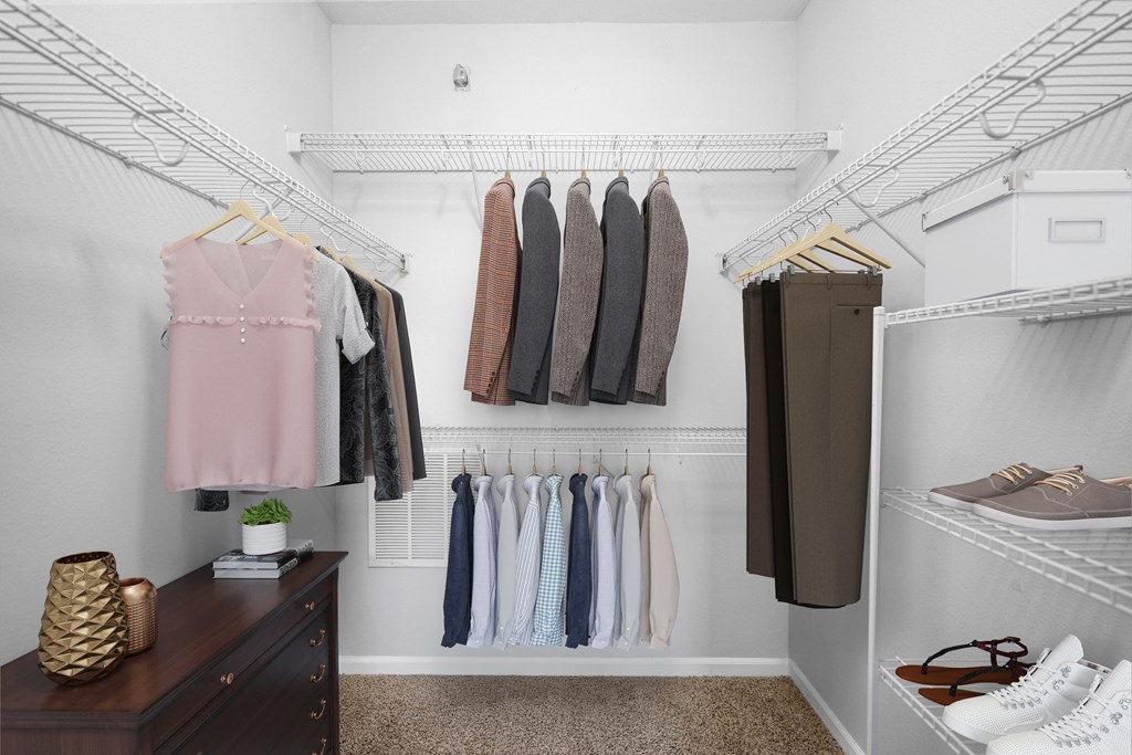 A walk in closet with clothes