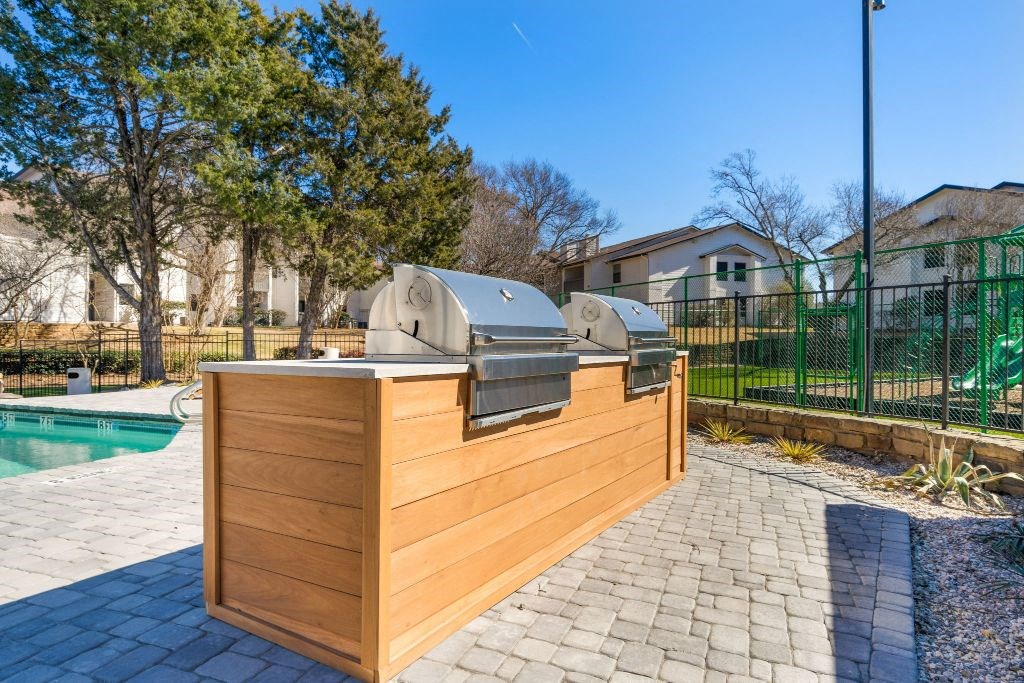 the backyard has a pool and a wooden bar with two hot tubs