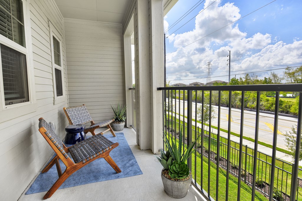 a balcony with two chairs and a view of a parking lot