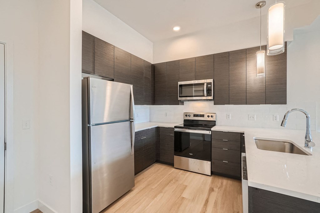 a kitchen with stainless steel appliances and a wooden floor
