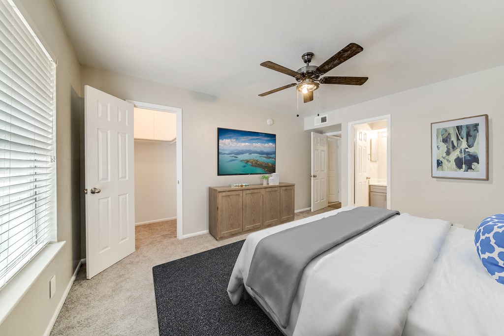 a bedroom with a bed and a ceiling fan