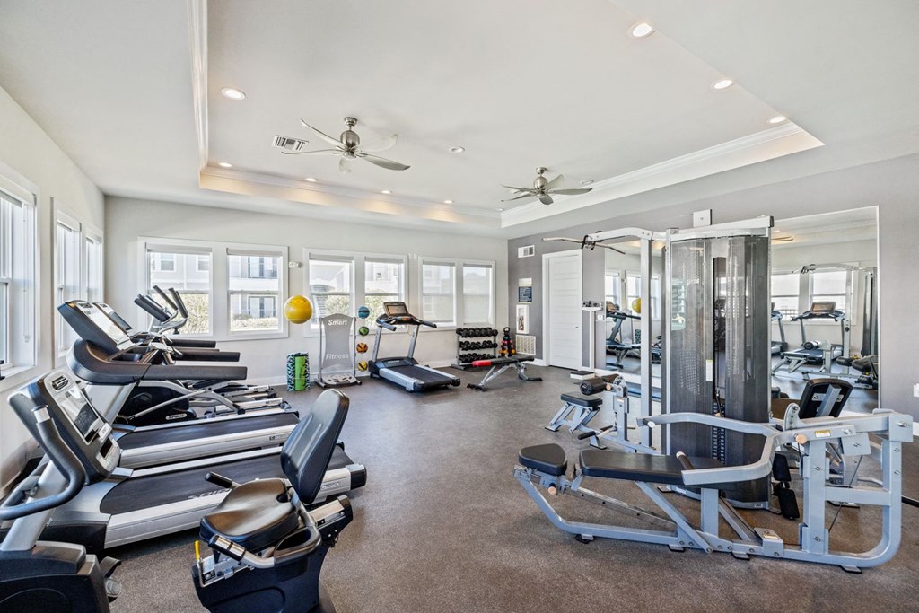 A spacious gym with treadmills, exercise bikes, and other equipment.