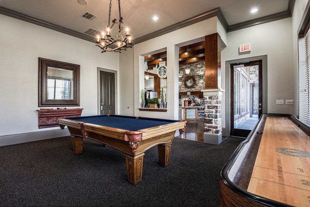 a game room with a pool table and a door to a bar
