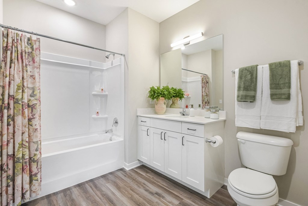 A white bathroom with a toilet, sink, and shower.