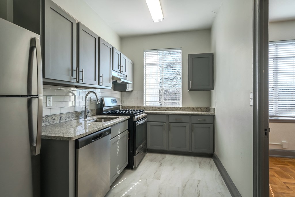 an empty kitchen with stainless steel appliances and granite counter tops