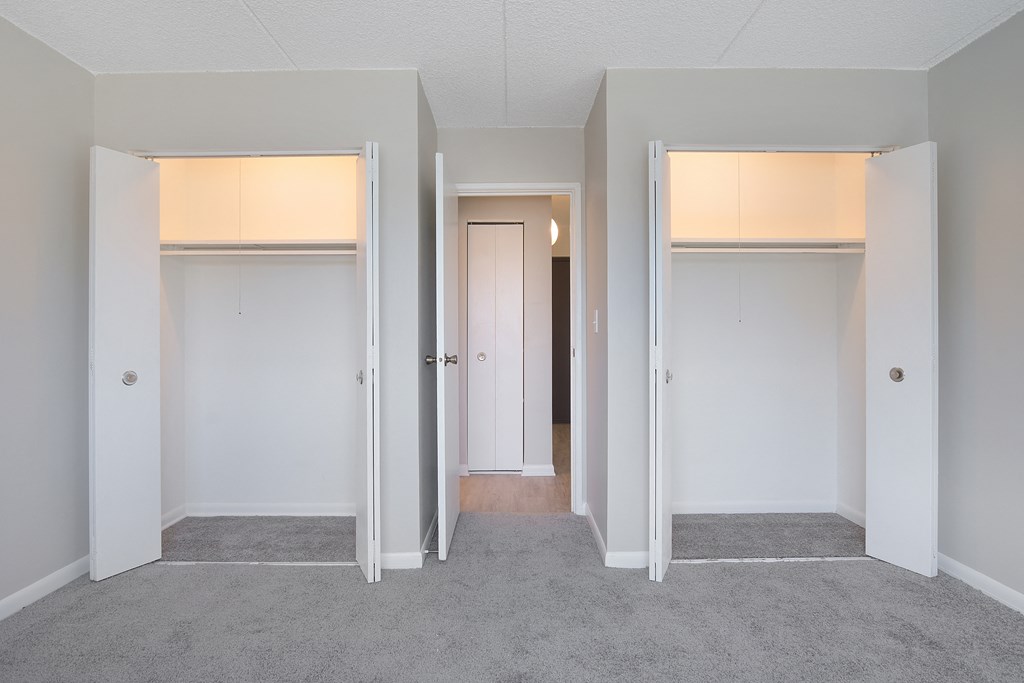 a living room with three doors and a hallway to three rooms