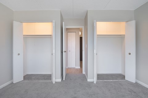 a living room with three doors and a hallway to three rooms