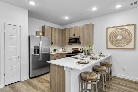 A kitchen with a white island and wooden cabinets.