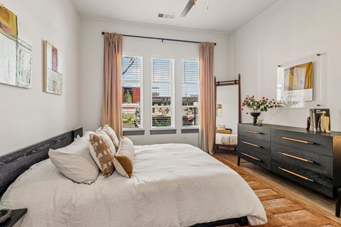 A bedroom with a large bed and a dresser.