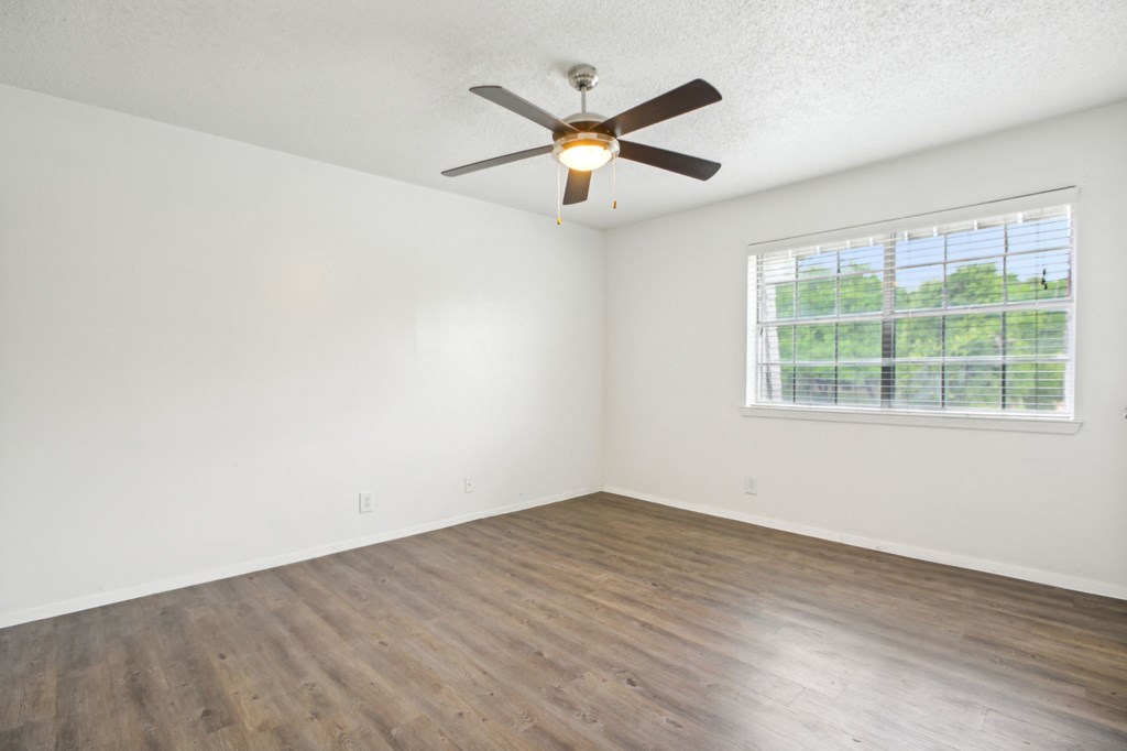 A room with a ceiling fan and a window.
