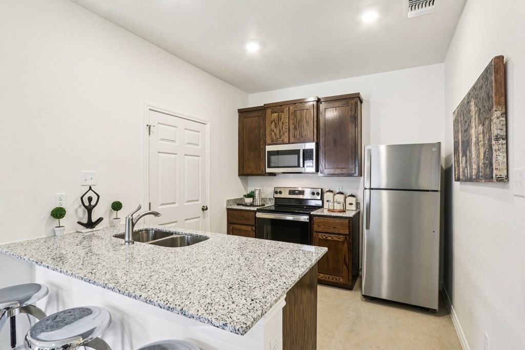A kitchen with granite countertops and stainless steel appliances.