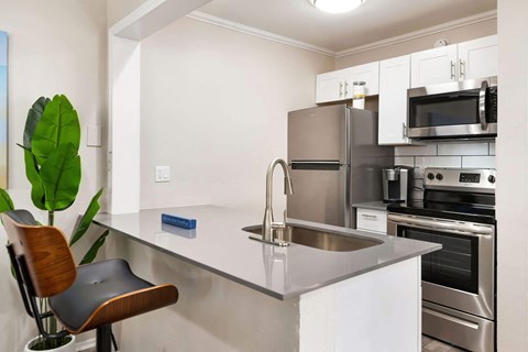 a kitchen with white cabinets and stainless steel appliances