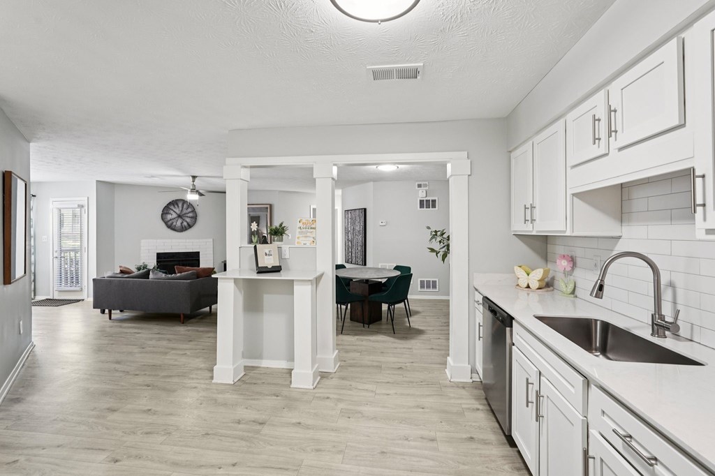 A kitchen with a dining table and chairs in the middle.