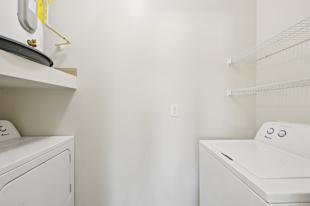 A white washing machine and dryer in a laundry room.