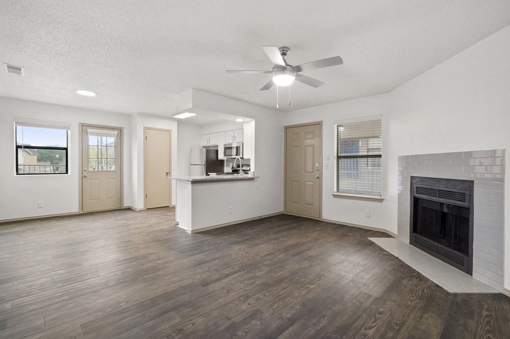 A living room with a fireplace and a ceiling fan.