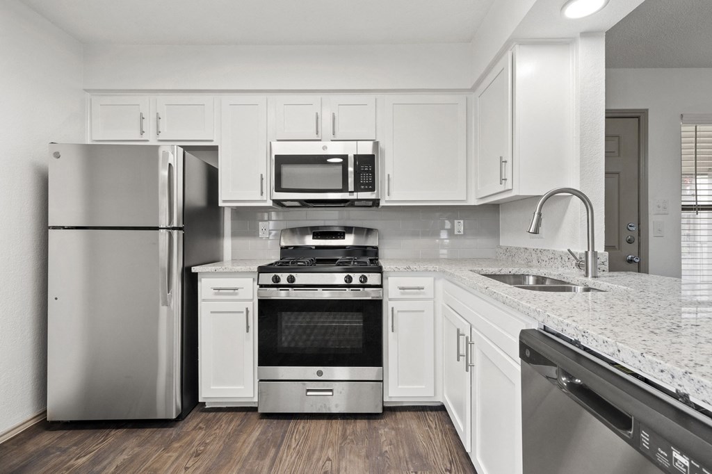 A kitchen with white cabinets and stainless steel appliances.