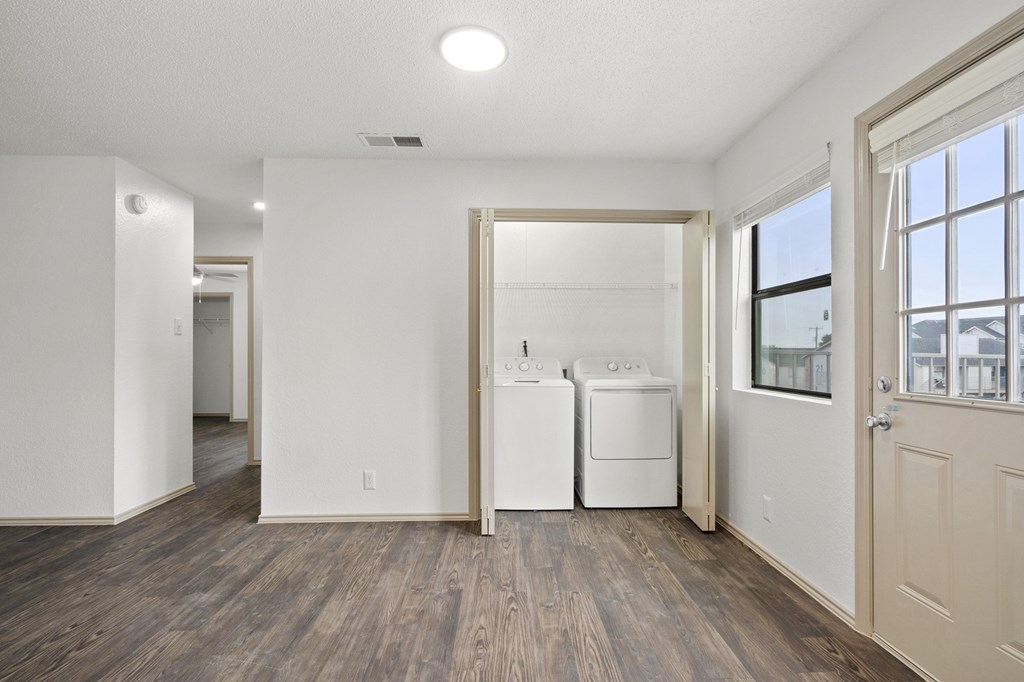 A white room with a washer and dryer in it.