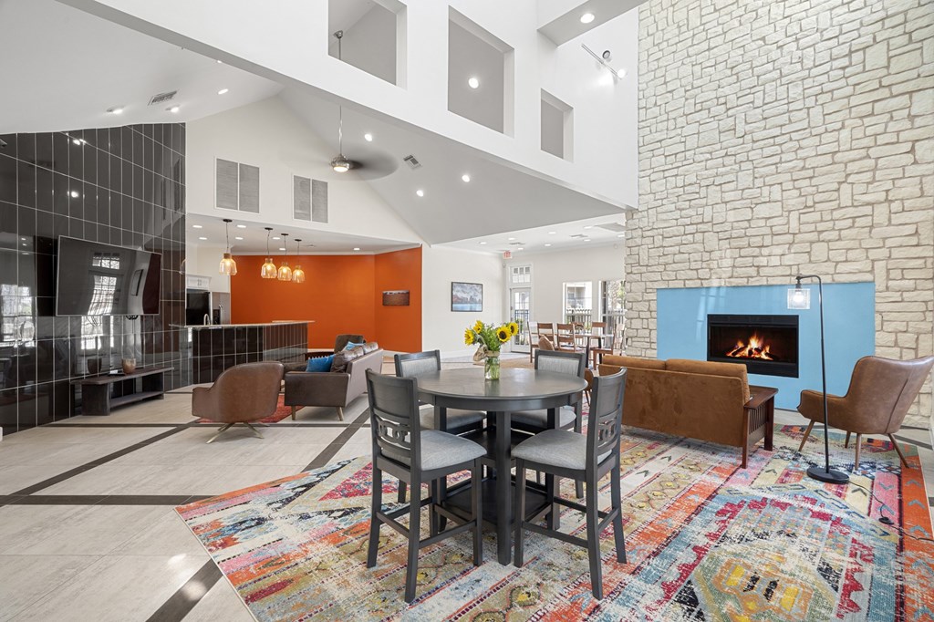 A modern living room with a brick wall and a fireplace.