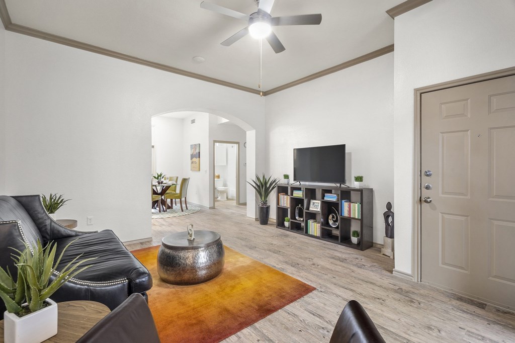 A living room with a black leather couch and a television.