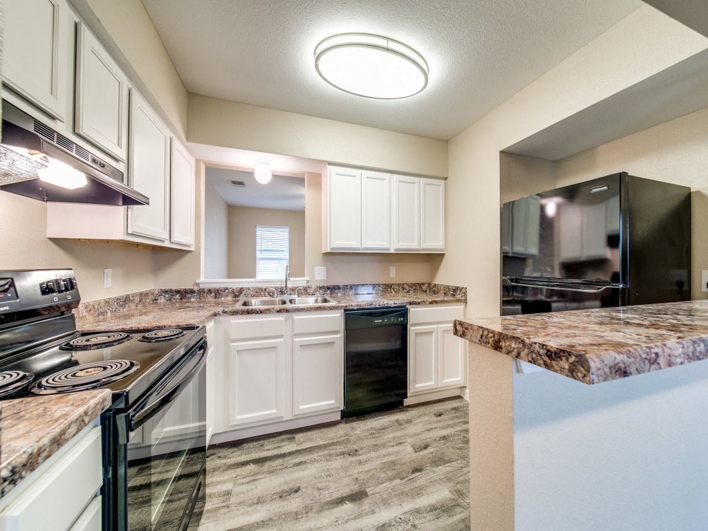 a kitchen with white cabinets and granite counter tops
