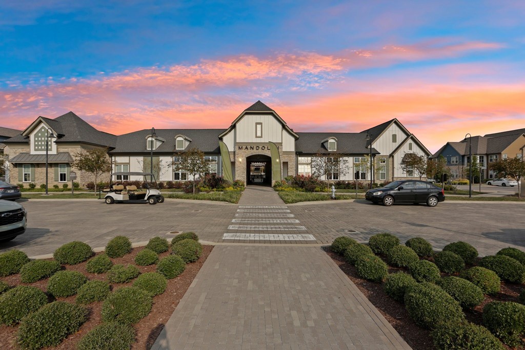 A large building with the word "MANOR" on it is surrounded by a parking lot.