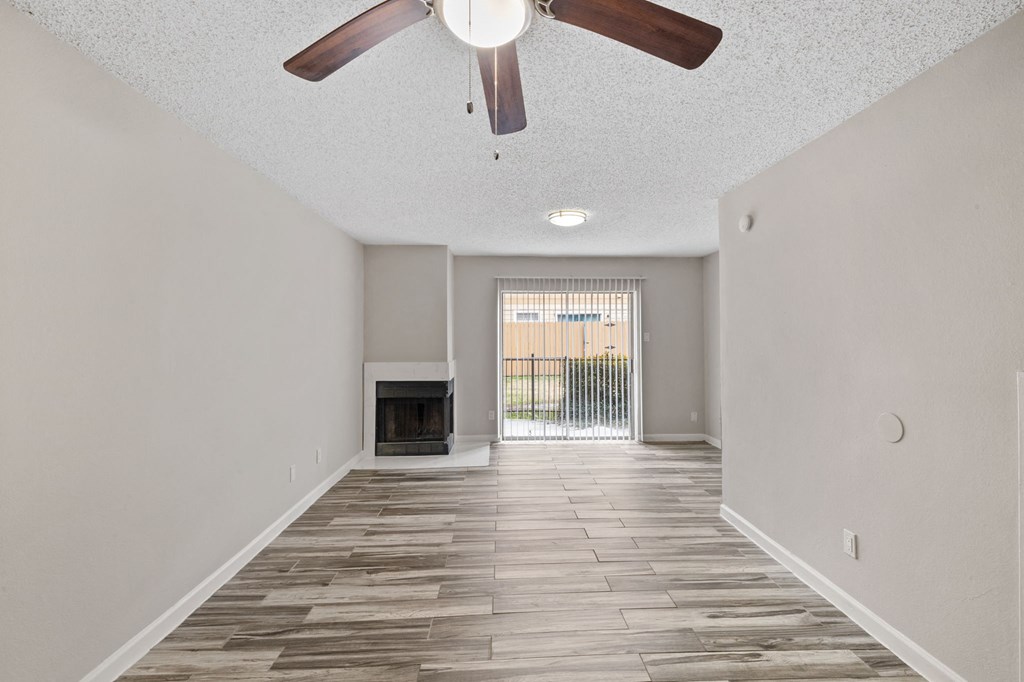 A room with a fireplace and a ceiling fan.