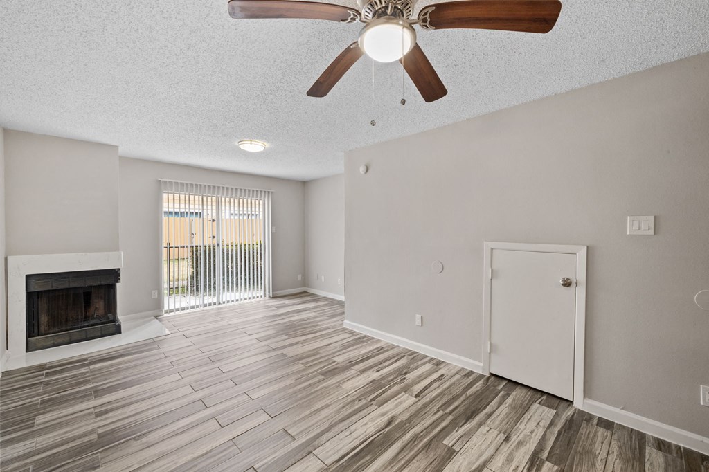 A room with a fireplace and a ceiling fan.