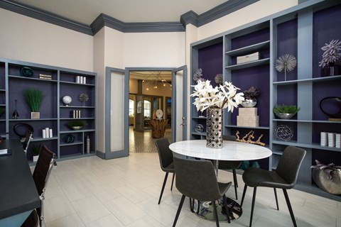 A dining room with a white table and chairs.