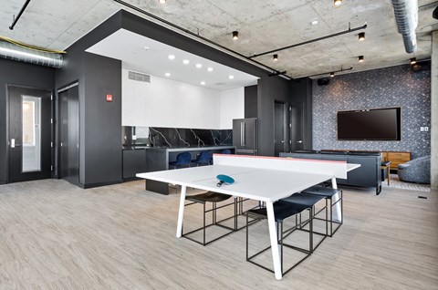 a dining room with a white table and chairs and a tv