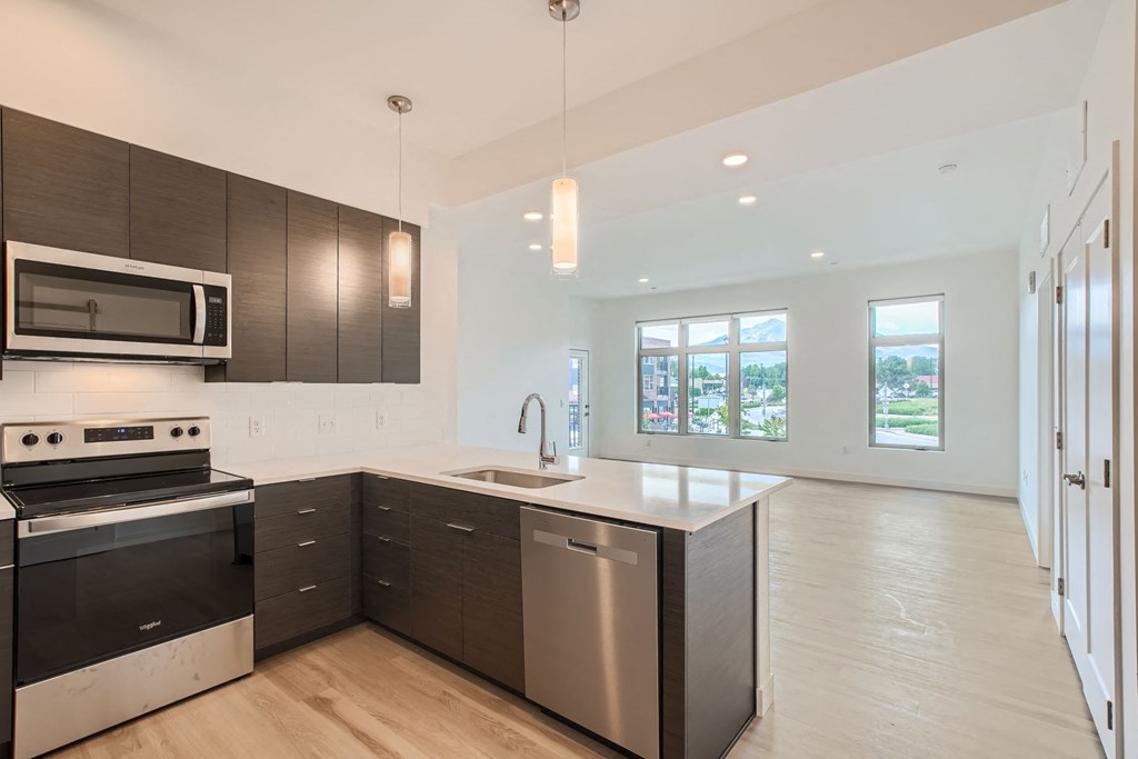 a kitchen with a large center island with a stainless steel dishwasher and a stove top oven