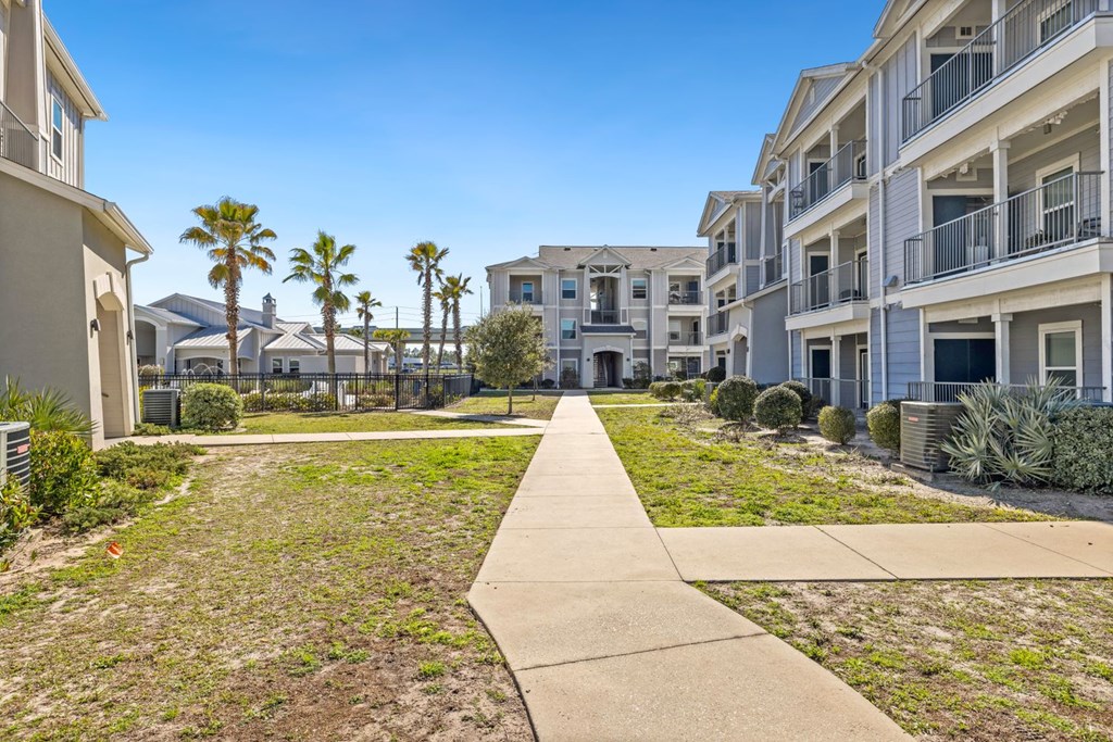 A sunny day at a residential area with apartment buildings and palm trees.
