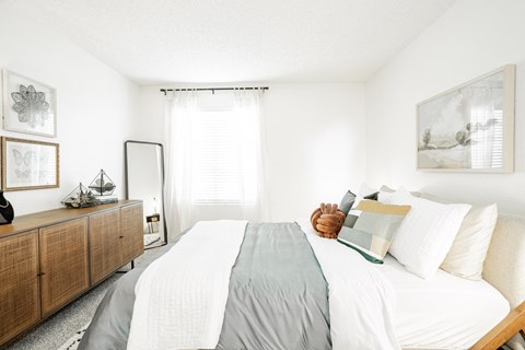 a bedroom with a large bed with white sheets and pillows