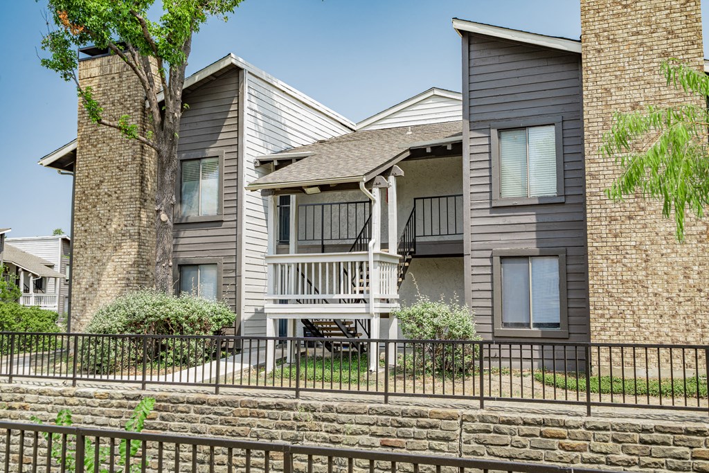 the outlook of an apartment building with a balcony and a fence