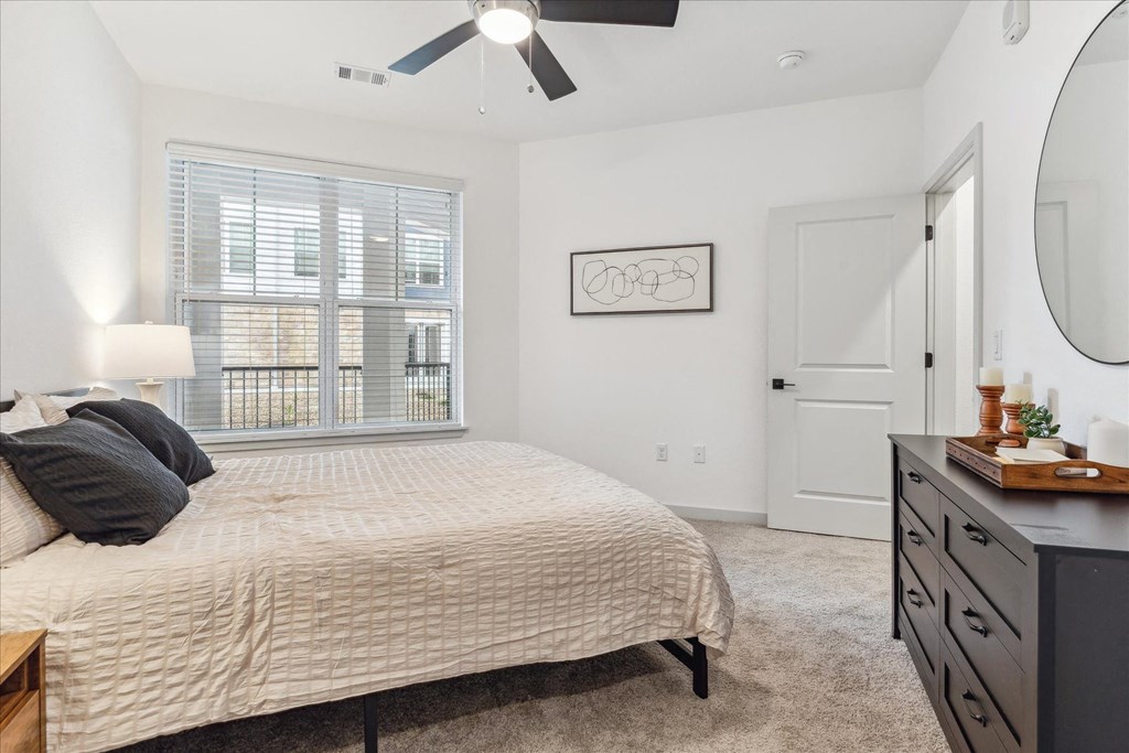 a bedroom with a bed and a ceiling fan