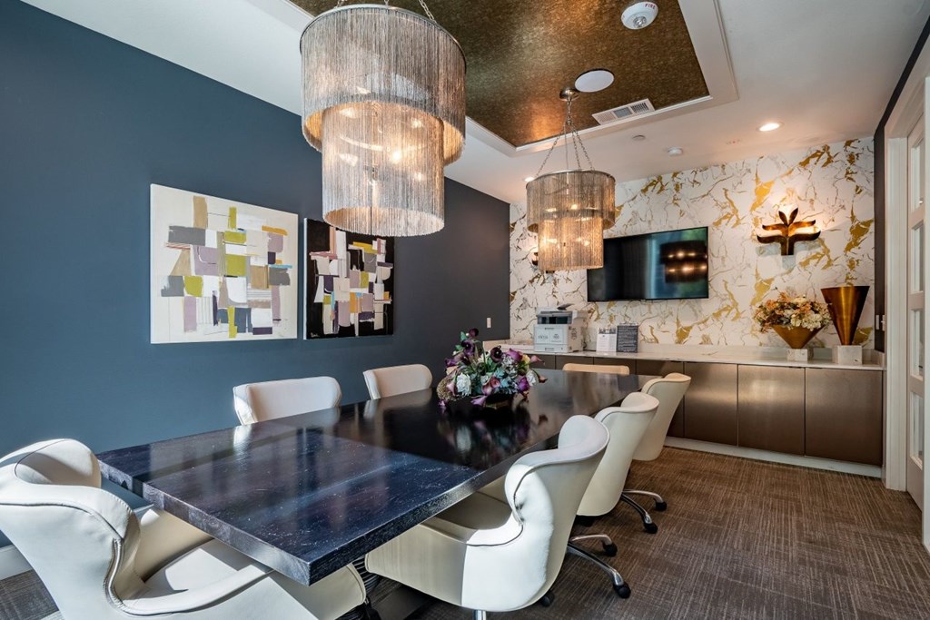 A modern dining room with a dark table and white chairs.